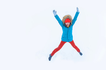 Fototapeta na wymiar High view of happy girl jumping and having fun on a snowy time. Smiling young woman at holiday with copy space 
