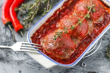 Baked meatballs from beef in tomato sauce with thyme