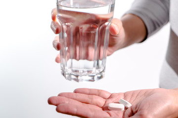 focus on the women hand holding the medicine with a glass of water, medicine recovery concept