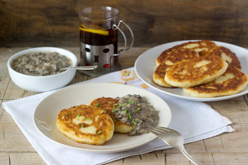 Potato cutlets or pancakes with mushroom sauce and green onions. Rustic style.