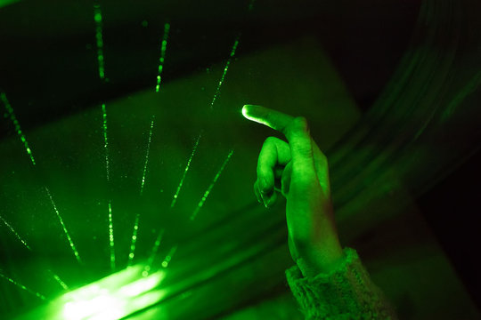 Close-up view of child hand playing laser harp.