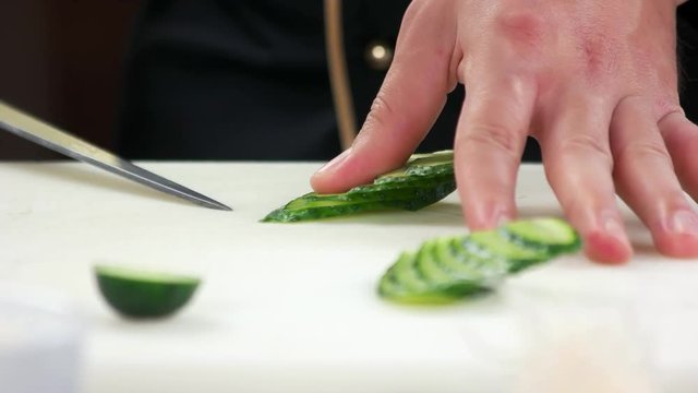 Hands cutting cucumber. Sliced fresh vegetable.