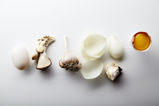 Asian cuisine ingredients on white background. Egg yolk, onion, garlic and oyster mushrooms