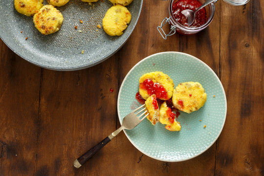 Homemade cheese pancakes with jar of raspberry jam. Breakfast table