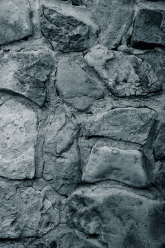Wall built of natural stone with cement. Toned