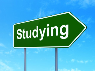 Learning concept: Studying on green road highway sign, clear blue sky background, 3D rendering