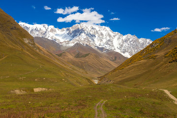 Fototapeta premium Colorful beautiful autumn landscape with snowy mountains in Svaneti. Georgia