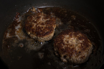 Cutlet fried in oil in a frying pan. Selective focus