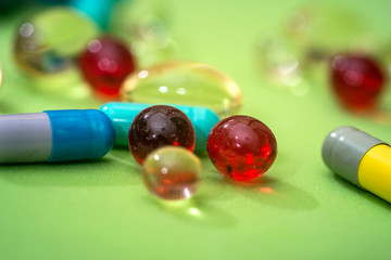 many different pills isolated on green background
