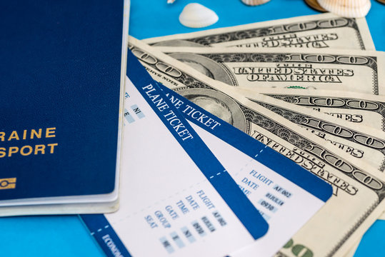 ticket with passport and dolls bills on blue