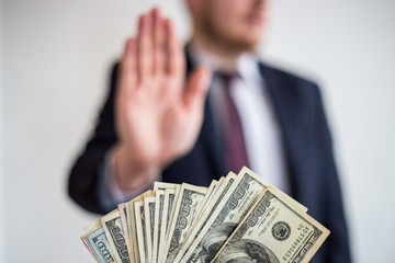 Bribe and corruption, offered cash to a businessman in a suit, does not want to take them, hold...