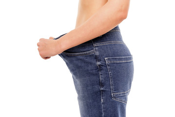 Woman shows that she has lost weight. Big jeans.