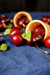 Waffle cones and cherries on blue background. Ingredients for a dessert cooking