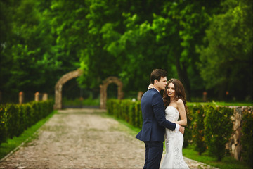 Naklejka premium Fashionable sensual young couple in a park - sexy bride and stylish groom