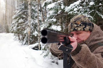 A hunter with a gun. Winter hunting. Huntsman.