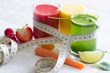 Fresh juices measuring tape fruits and vegetables lose weight diet concept
