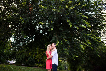 A loving couple hugs and walks in the park.