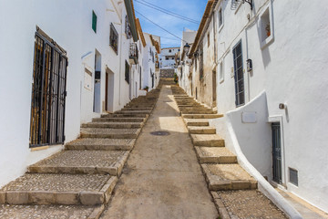 Steep narrow road with white houses in Altea