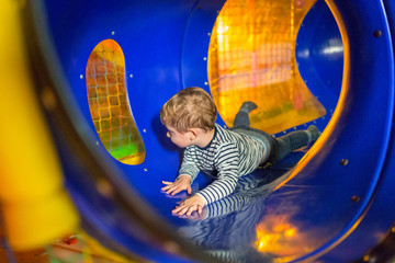Little boy in the playground tunnel