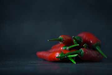 a lot of red chili pepper on dark ground