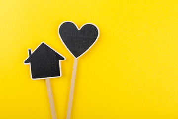 Black chalkboard heart and house on a wooden stick. Mothers day background
