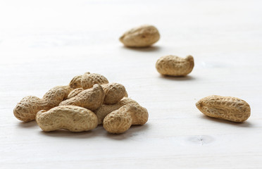 Handful of peanuts in shell on a white table