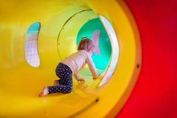 Little girl in the playground tunnel