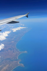 Obraz premium Coral Reef and detail of land and sea with airplane's wing. View from plane window.