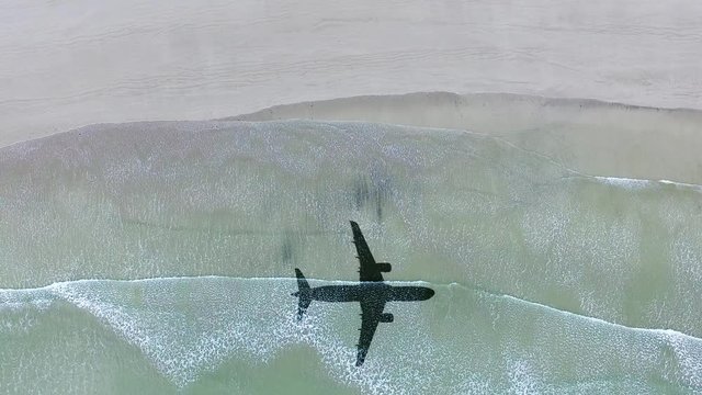 Aerial View of lonely beach with shadow of airplane