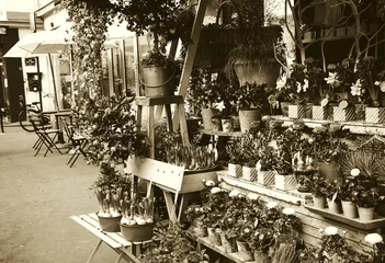Wall murals Flower shop Outdoor flower shop on Parisian street. Cafe tables and bicycle at background. Paris (France). Sepia.