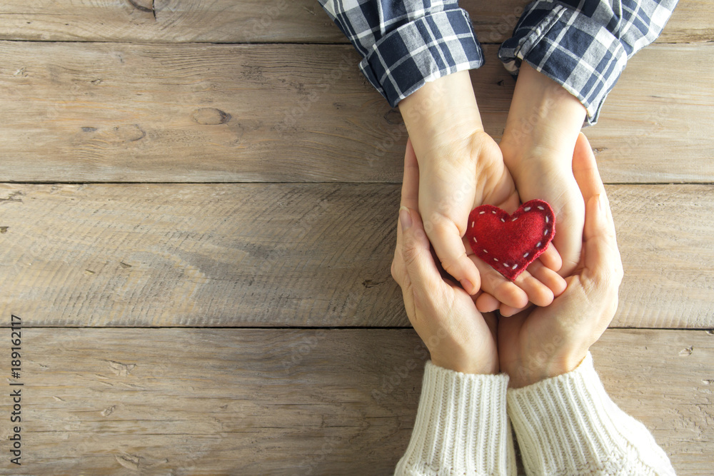 Wall mural Red heart in hands