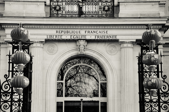 Fototapeta Chinese New Year celebration in Paris. City hall of 3rd arrondissement of Paris decorated with Chinese traditional red lanterns. Liberty, equality, fraternity is written over entrance. Black and white