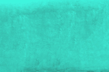 Fototapeta na wymiar Vivid green turquoise color coarse facade wall as an empty rustic background texture space.
