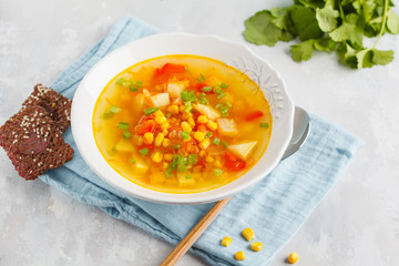 Healthy summer vegetable corn soup in a white plate with flax crispy bread. Vegan Healthy Food Concept. Top view