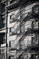 Outside metal fire escape stairs, New York City, black and white