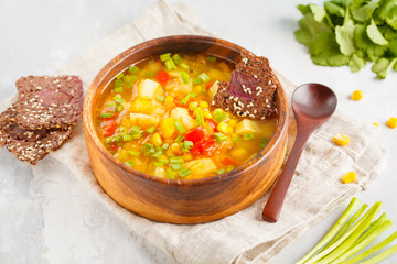 Healthy bright vegetable corn soup in a wooden bowl with flax crispy bread. Vegan Healthy Food Concept.