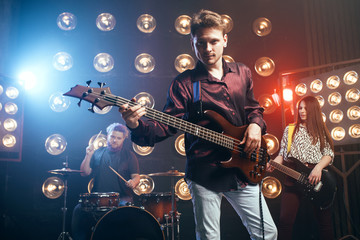 Obraz premium Guitarist plays on bas guitar, rock band