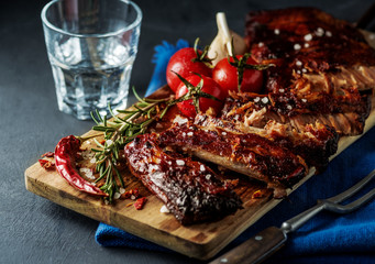 Delicious barbecued ribs seasoned with a spicy basting sauce and served with chopped fresh...