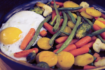 Fototapeta na wymiar fried egg with vegetables in a frying pan