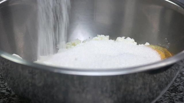 Preparing dough, adding sugar. Close up pouring sugar to eggs and chopped cheese.