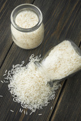 Raw Basmati rice grits poured out of a glass jar