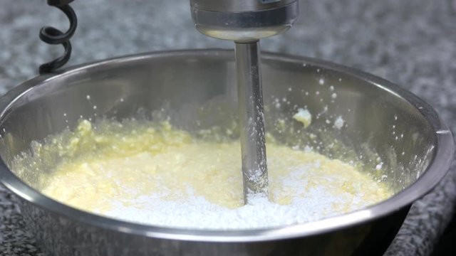 Adding flour to the dough. Chef hands pouring white flour to the dough in bowl.