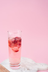 A glass of cocktail with frozen strawberry and lingonberry