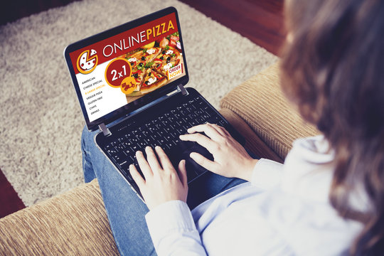 Woman ordering pizza by internet while sitting at home.
