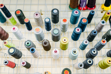 Colorful threads on spools closeup, side view