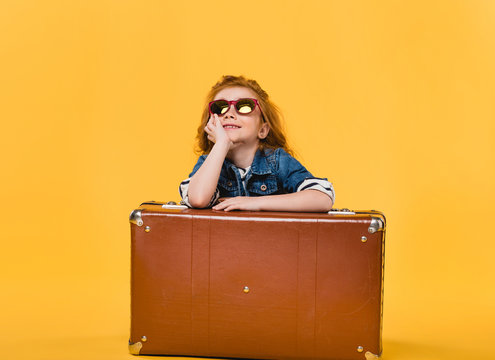 Stylish Child In Sunglasses With Suitcase Isolated On Yellow