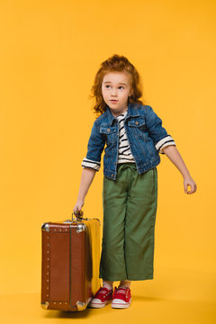 Stylish Child Holding Suitcase Isolated On Yellow