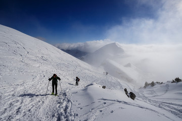 Fototapeta na wymiar alpinisti che scendono dalla cima di Piazzo. Sullo sfondo mi monte Sodadura tra le nubi - alpi Orobie