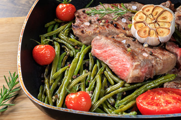 Fried meat with garlic and vegetables in a pan.