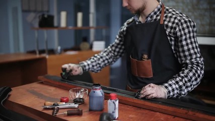 Leather handbag craftsman at work in a workshop